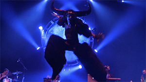 dancer with horns and stilts jumping on stage