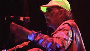 Raja Ram on stage with neon green hat