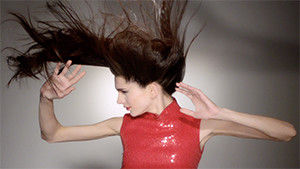 brunette fashion model hair blowing in the wind arms reaching