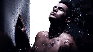 male fashion model in studio topless with splashing water