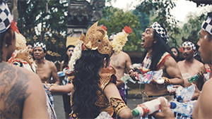 Balinese dance traditional costumes at temple holding plastic bottles