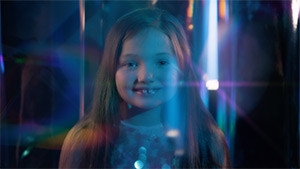 young girl smiling with colorful lighting in be your own beautiful music video