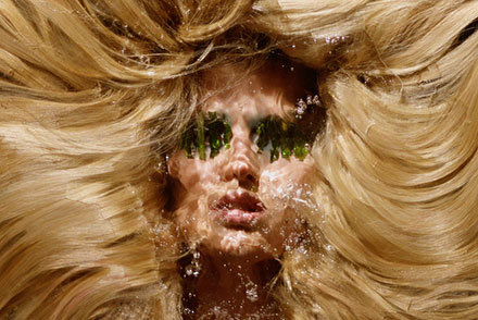 Fashion model in studio with big hair and water in front of face