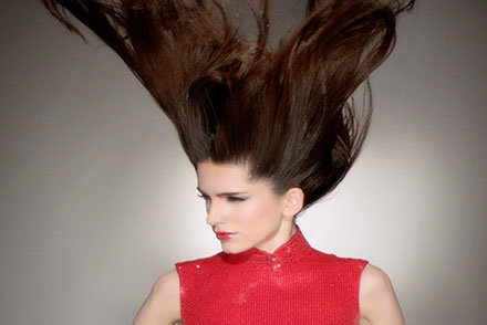 fashion Model with hair blowing in a red sleeveless shirt